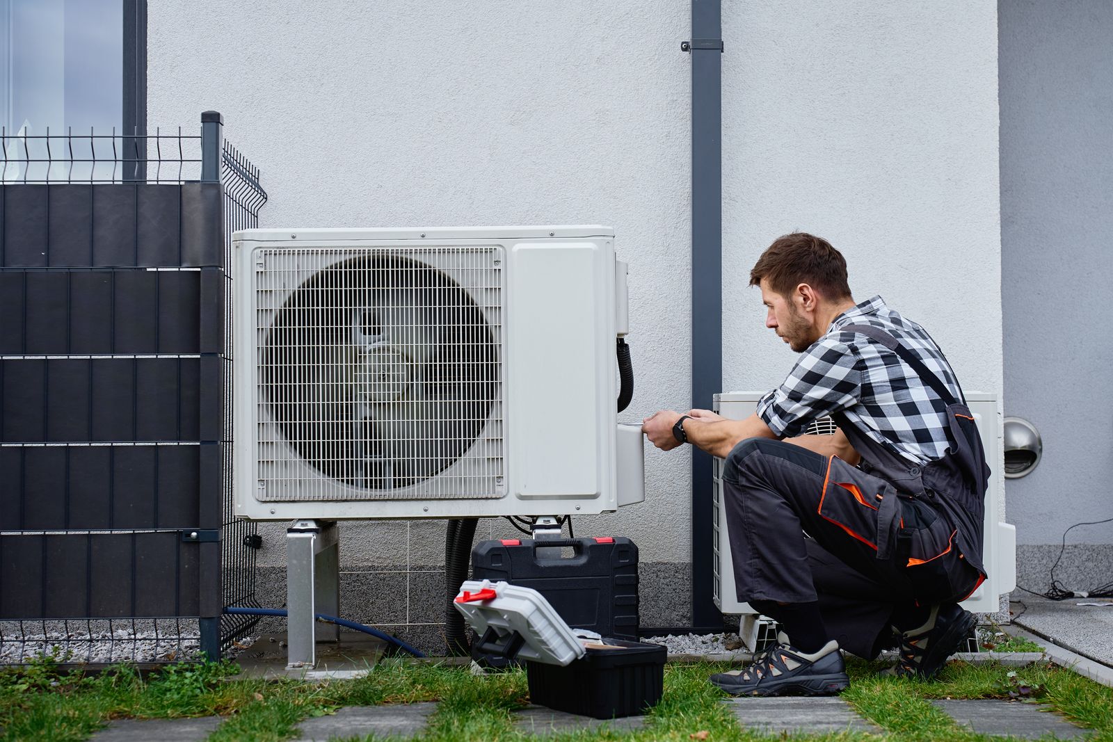 Servicetechniker arbeitet an einer Wärmepumpe im Garten